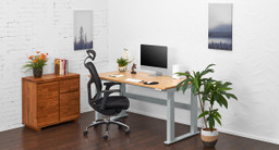 The UPLIFT V2-Commercial 4-Leg Frame in gray with a rubberwood desktop