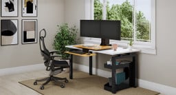 Bamboo E7 Standing Desk Converter in seated position showing the lower keyboard tray positioned lower than the desktop surface
