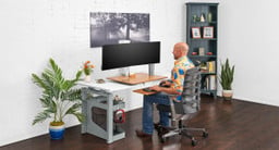 Bamboo E7 Standing Desk Converter supported by a fixed height 48" x 30" 4-Leg Offset Seated Height Side Table
